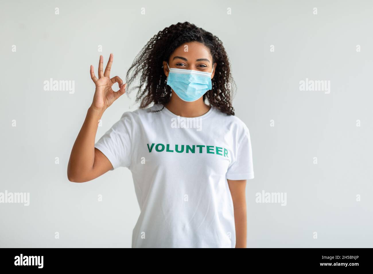 Travail libre volontaire, concept de grâce de charité.Bonne femme volontaire dans le masque médical montrant le geste OK Banque D'Images