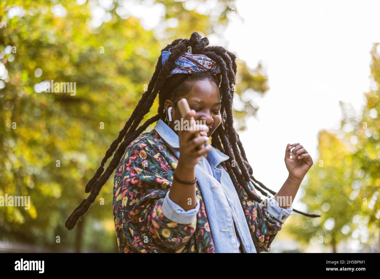 Jeune femme qui apprécie la danse et écoute de la musique en plein air Banque D'Images