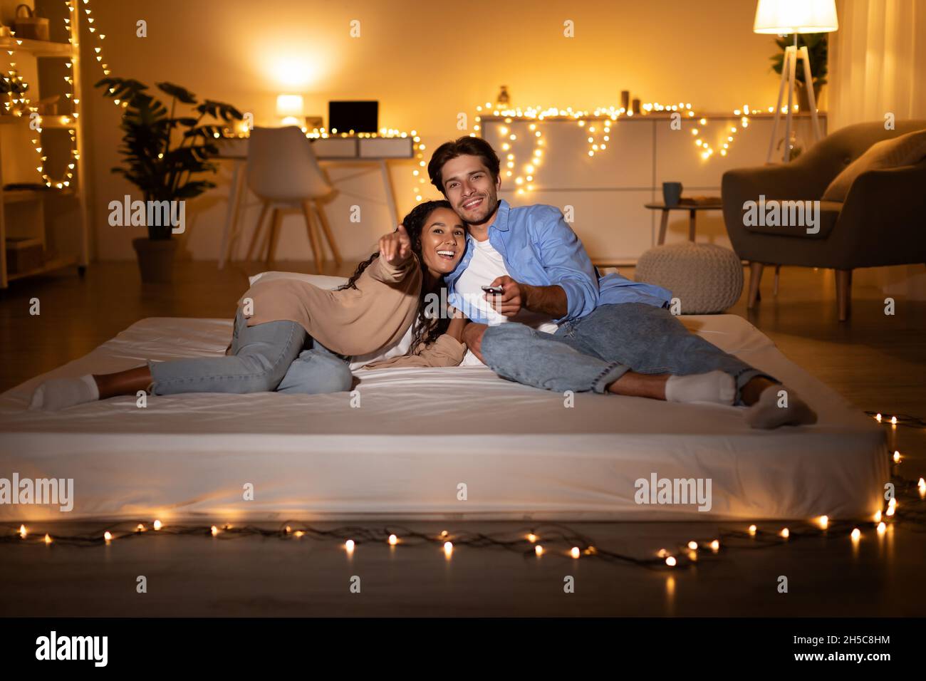 Couple regardant un film à la télé couché sur un matelas à la maison Photo  Stock - Alamy