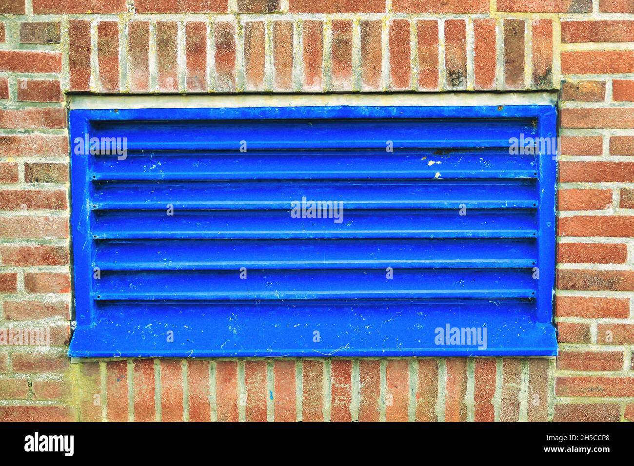 Conduit de ventilation bleu dans un bâtiment industriel entrée et sortie d'air du système de ventilation dans un bâtiment industriel.Calandre bleue dans un Wal en briques Banque D'Images