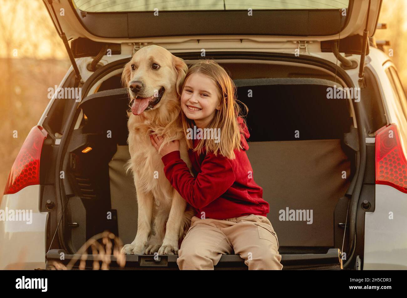 Fille avec chien Golden Retriever en voiture Banque D'Images