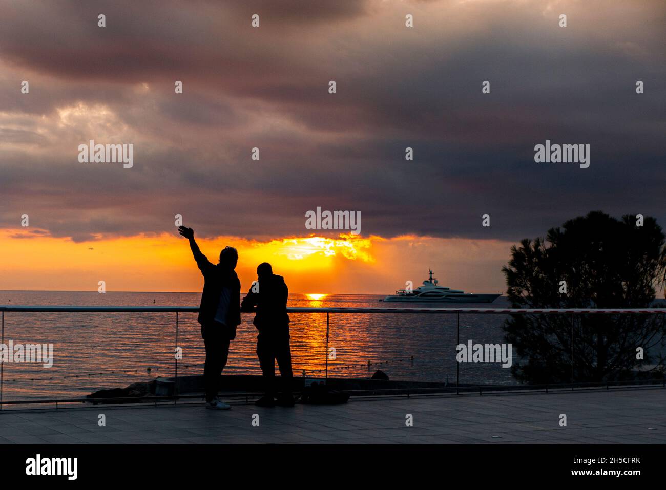 Deux personnes sur le front de mer à Monaco, en signe de vente de yacht à l'aube Banque D'Images