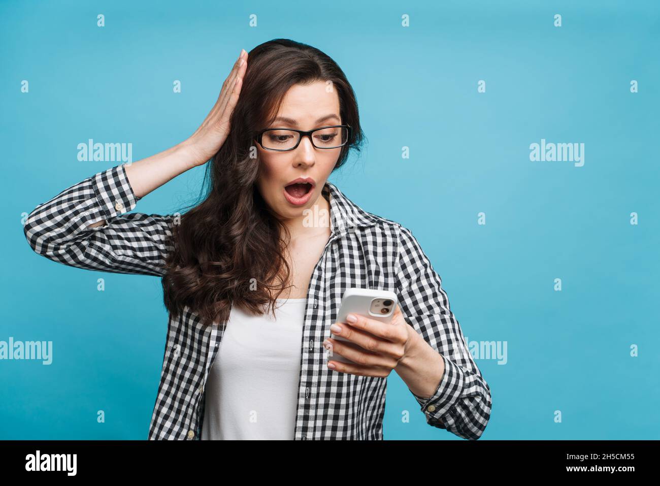 Une femme bouleversée qui a découvert les mauvaises nouvelles.Perte de finances, faillite d'une entreprise, chute du taux de change des titres.La brunette regarde Banque D'Images