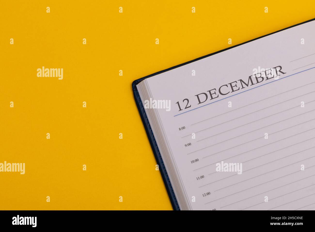Bloc-notes ou agenda avec la date exacte sur fond jaune.Calendrier pour décembre 12 - heure d'hiver.Espace pour le texte. Banque D'Images