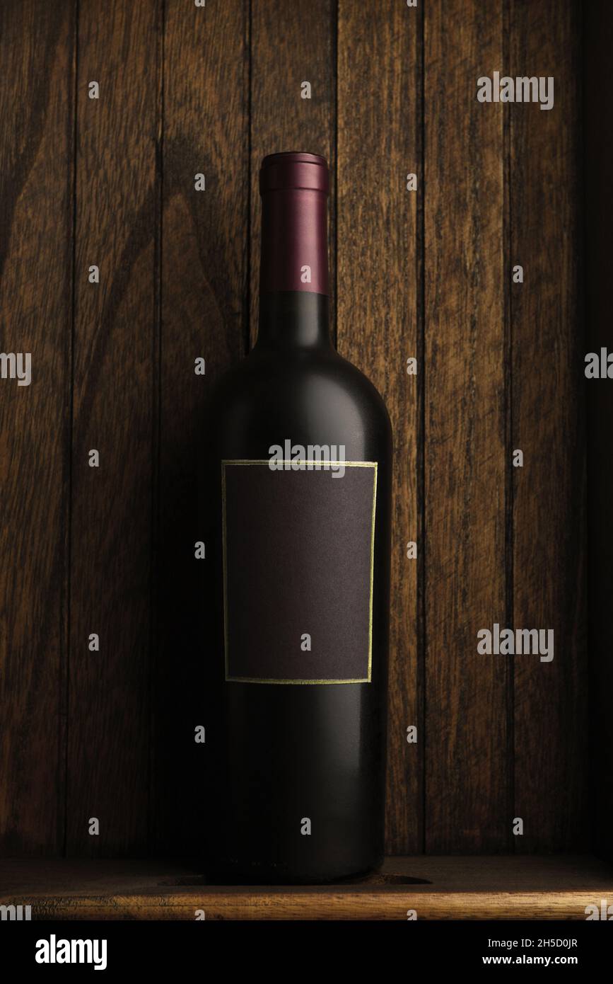 Bouteille de vin Still Life : une seule bouteille de vin dans une boîte en bois rustique.Format vertical avec espace de copie. Banque D'Images