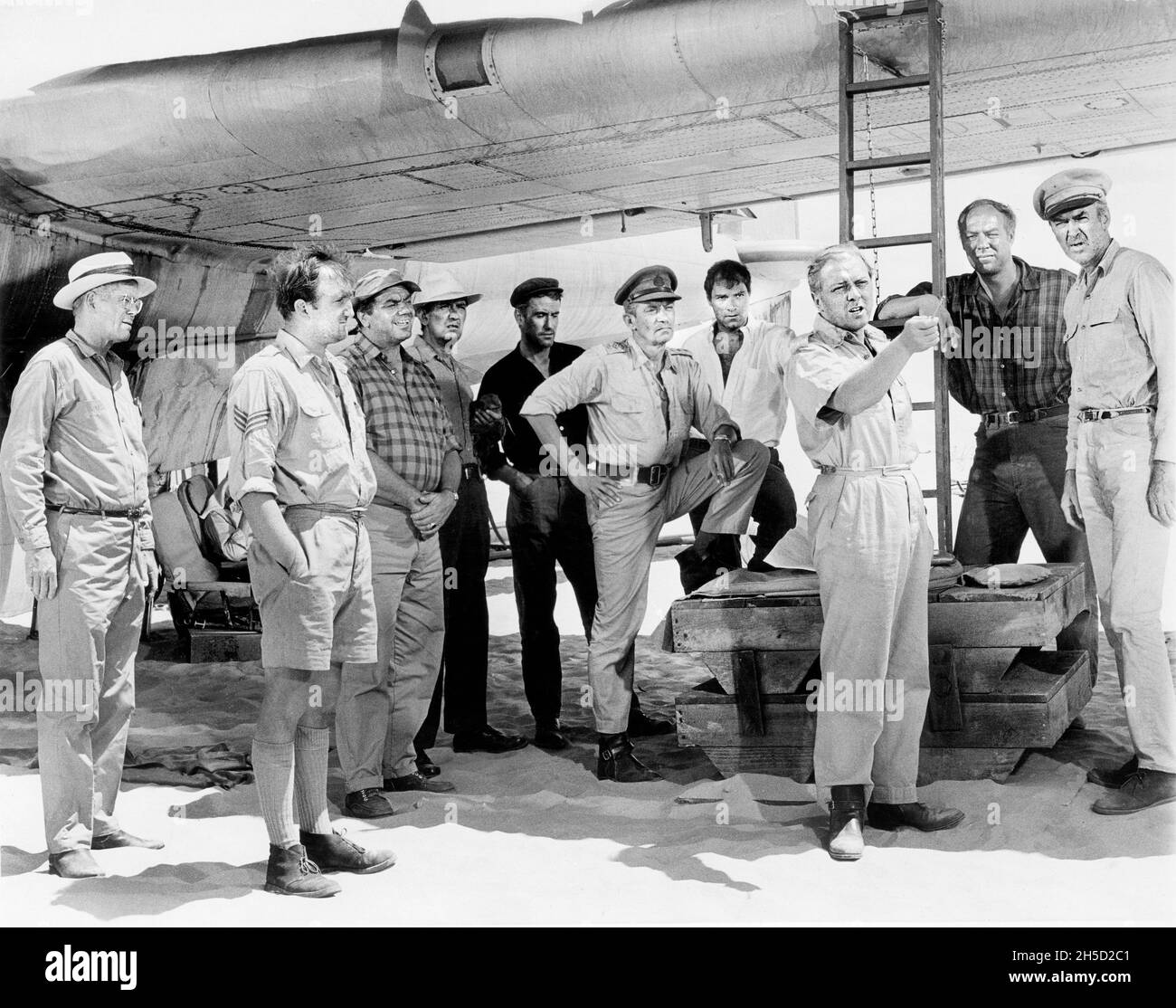 DaN Duryea, Ronald Fraser, Ernest Borgnine, Ian Brennan, Peter Finch,Christian Marquand, Richard Attenborough, George Kennedy, James Stewart, sur le tournage du film, « The Flight of the Phoenix », Fox du XXe siècle, 1965 Banque D'Images