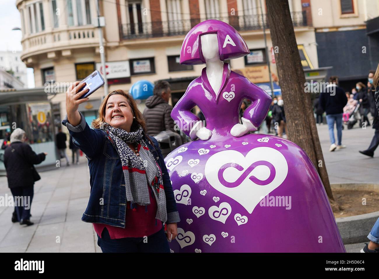 Madrid, Espagne.08 novembre 2021.Une femme prend un selfie avec la sculpture de 'Mininas' par l'artiste Antonio Azzato est exposé avec le titre Lucha contra la violencia de genero, lors de la quatrième édition de 'Mininas Madrid Gallery', une galerie d'art en plein air à travers les rues du centre de Madrid.Crédit : SOPA Images Limited/Alamy Live News Banque D'Images