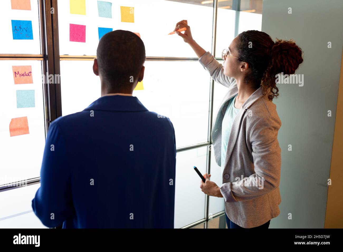 Les femmes d'affaires multiraciales planifient une stratégie d'affaires plutôt que des notes adhésives colorées dans le bureau créatif Banque D'Images