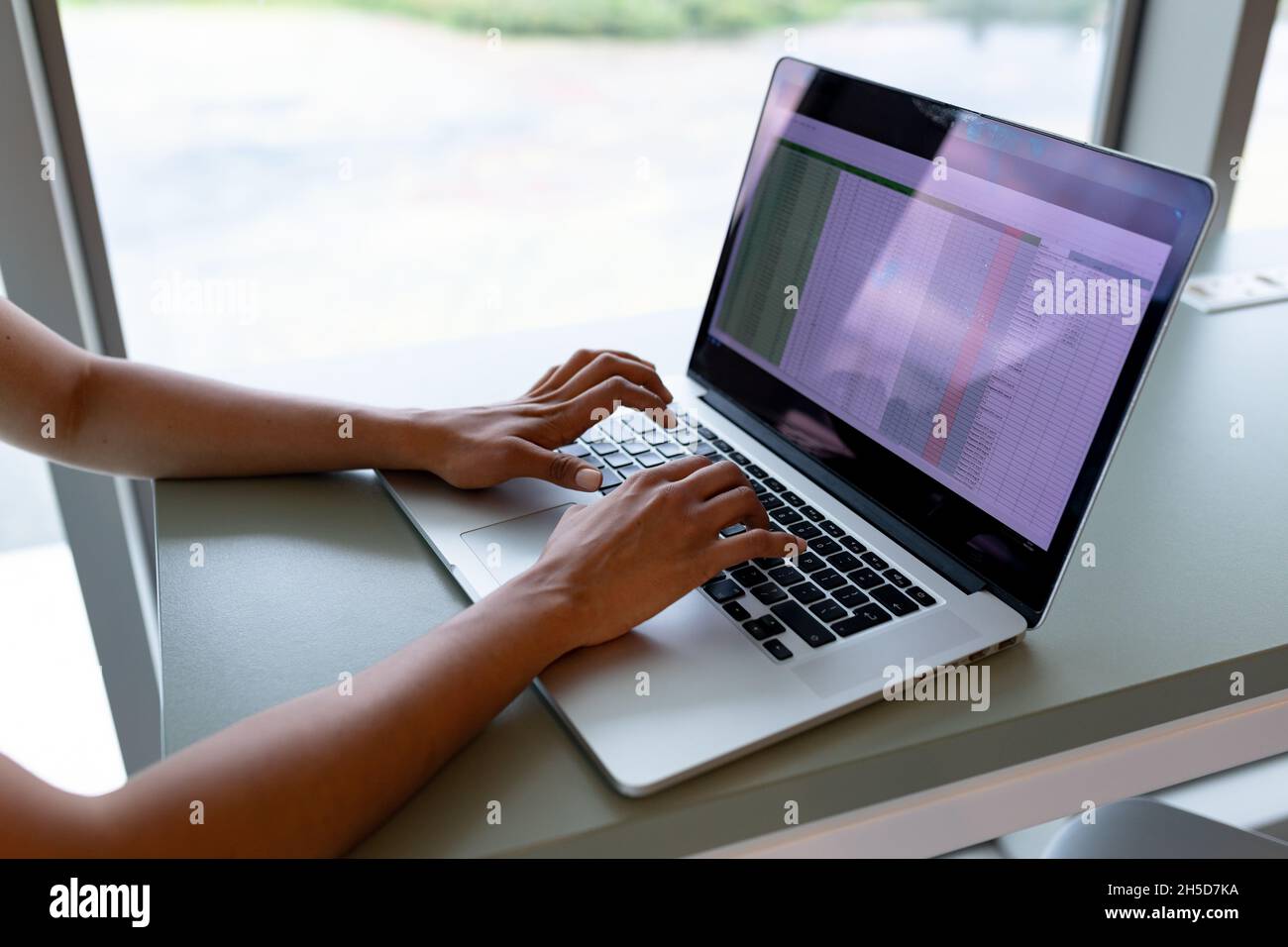 Les mains d'une femme d'affaires travaillant sur un ordinateur portable au bureau dans un bureau créatif Banque D'Images