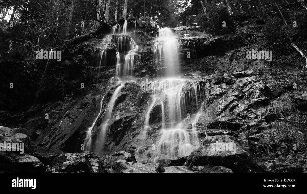 Prise de vue en niveaux de gris de cascades sur des rochers à longue exposition Banque D'Images