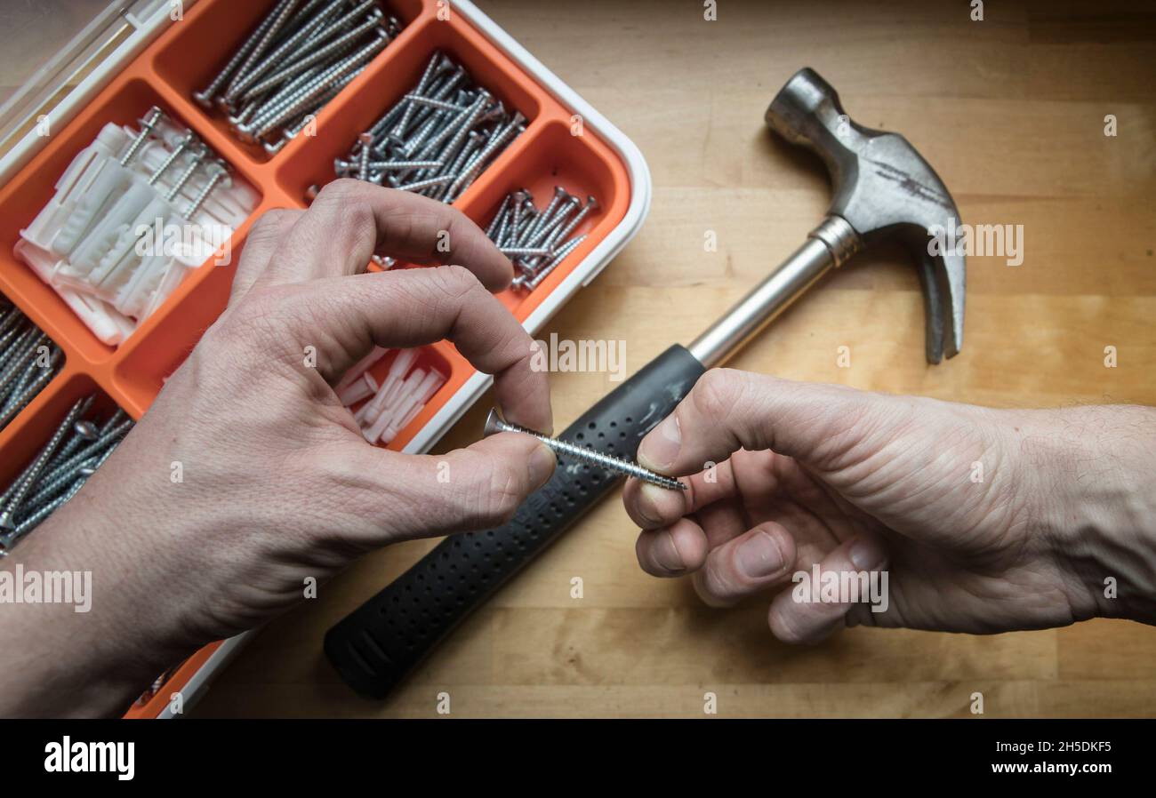 PHOTO POSÉE PAR LE MODÈLE photo du dossier datée du 05/03/17 d'un homme tenant une vis.Une enquête a révélé qu'environ une personne sur 10 (10 %) avait apporté des articles pendant la pandémie du coronavirus qu'elle regrette maintenant d'acheter.En moyenne, les personnes qui ont avoué leurs regrets ont dépensé 1,376 £ pour des articles dont ils ont maintenant une seconde réflexion, selon Aviva.Date de publication : le mardi 9 novembre 2021. Banque D'Images