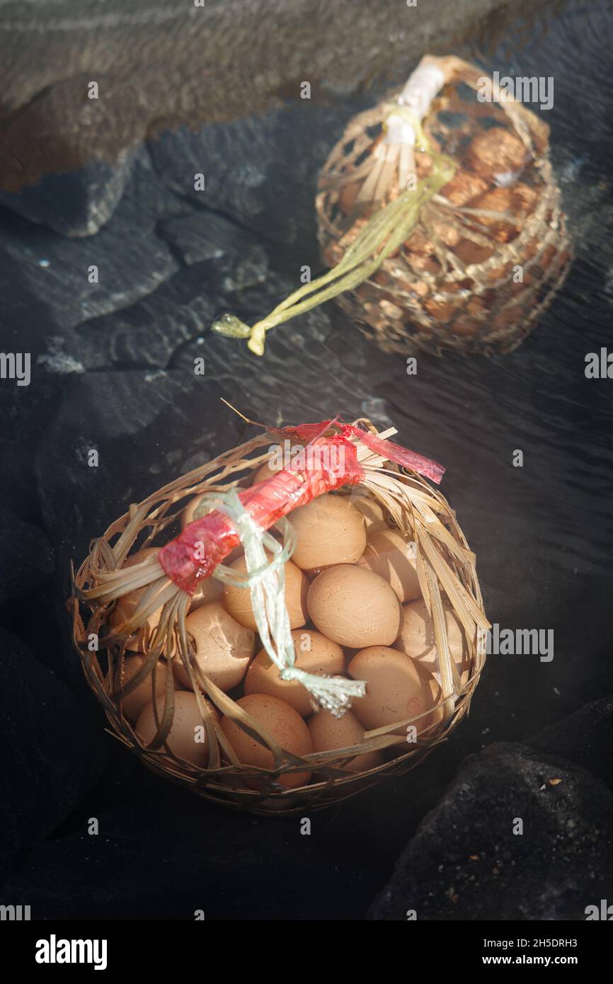 Grands paniers d'œufs cuits sous l'eau bouillante de l'étang d'eau minérale chaude à la source chaude. Banque D'Images