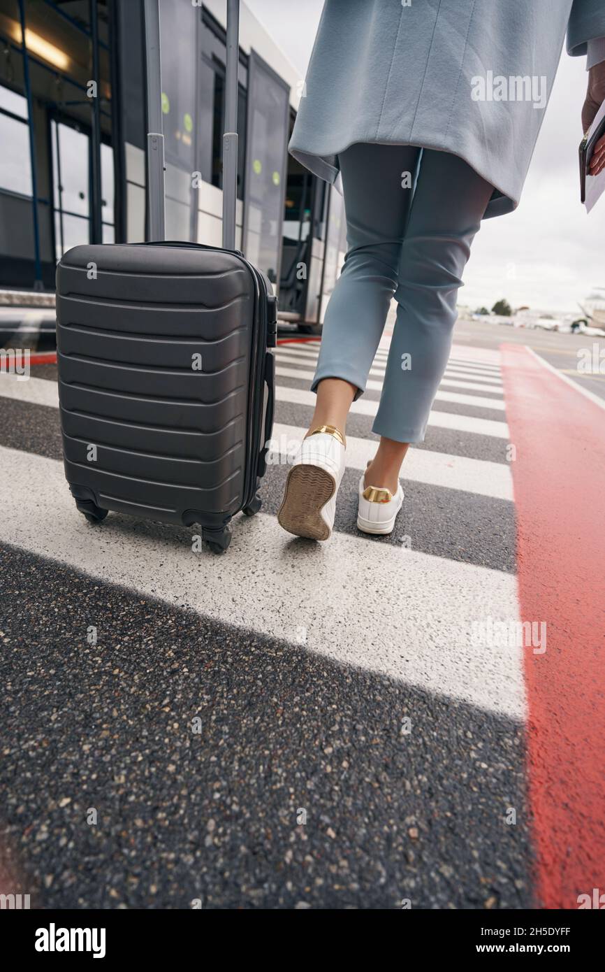 Passager avec document de voyage et bagages approchant du véhicule de transport Banque D'Images