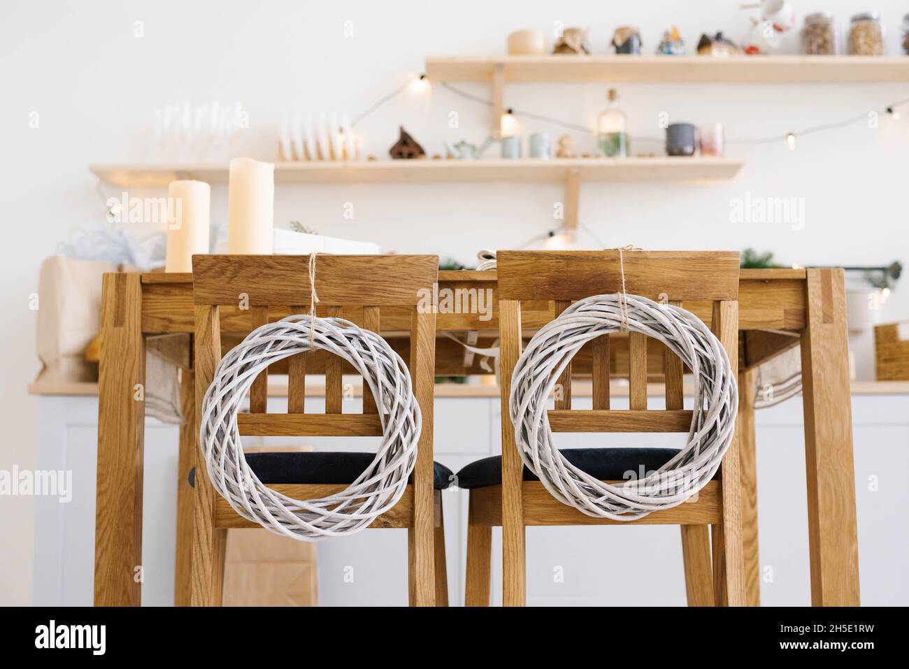 Chaises de cuisine en bois décorées de couronnes de Noël dans la cuisine scandinave Banque D'Images