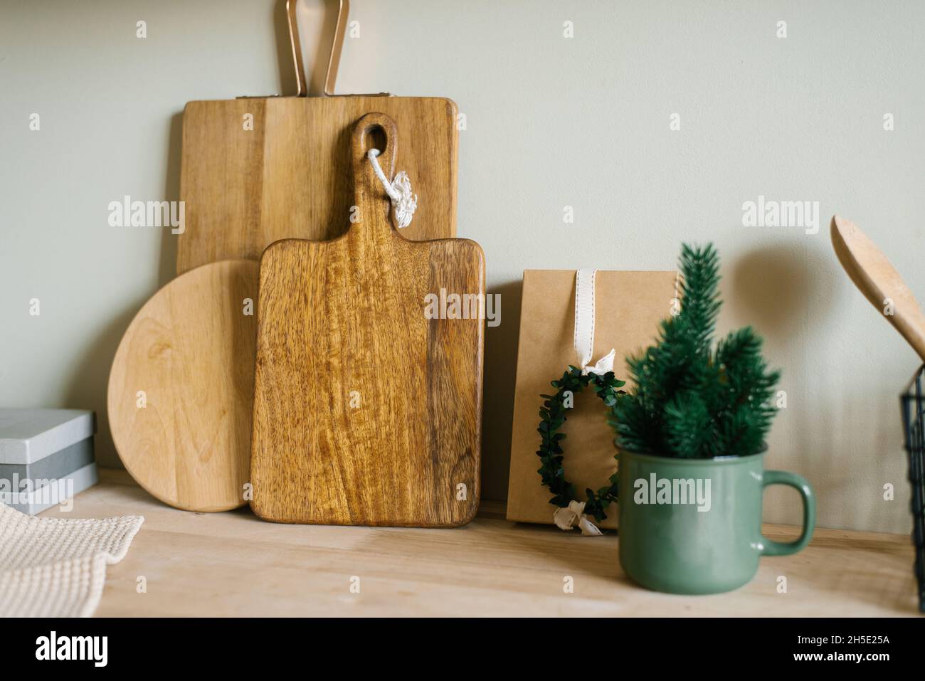 Arbre de Noël dans une tasse en métal vert et planches à découper en bois dans le décor de la cuisine scandinave Banque D'Images
