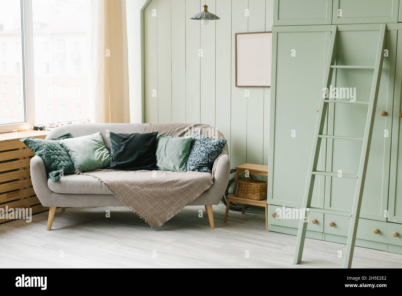 Décoration scandinave élégante dans la chambre, couleur menthe.Canapé et  armoire avec escalier Photo Stock - Alamy