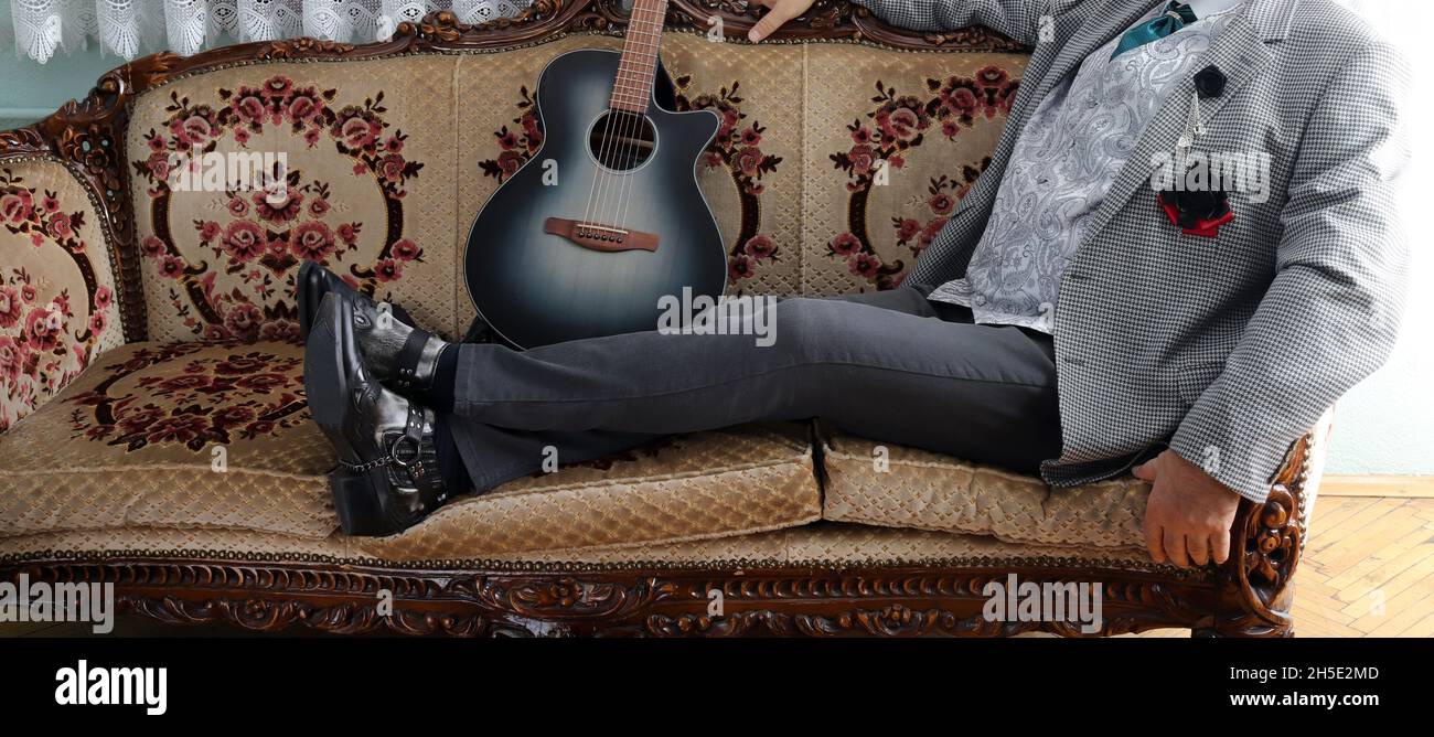 Bottes de cowboy et guitare.Il se repose. Banque D'Images