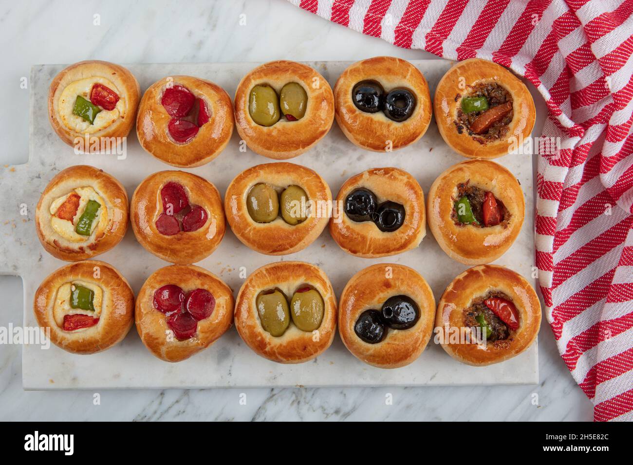 Mini hot dogs servis sous forme de buffet.Mini pizzas avec assortiment de légumes, mozzarella et basilic frais sur fond de marbre, vue rapprochée du dessus. Banque D'Images