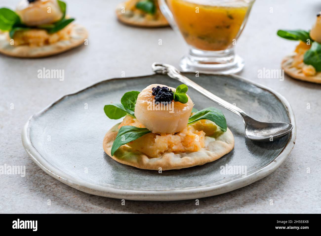 Canapés aux noix de Saint-Jacques, caviar et sauce au citron vert et au beurre Banque D'Images