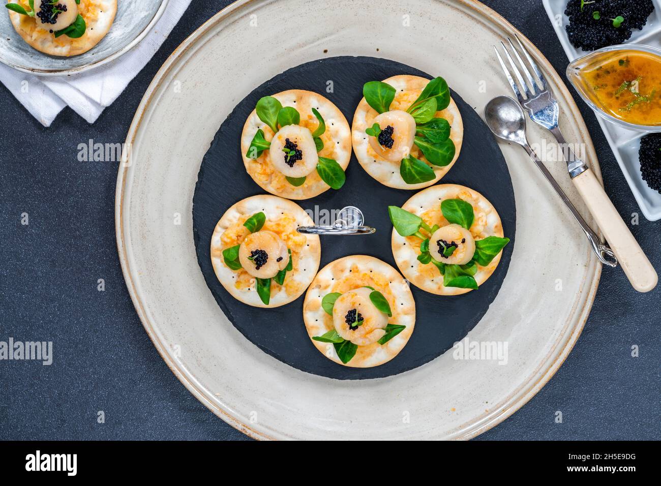 Canapés aux noix de Saint-Jacques, caviar et sauce au citron vert et au beurre - vue de dessus Banque D'Images