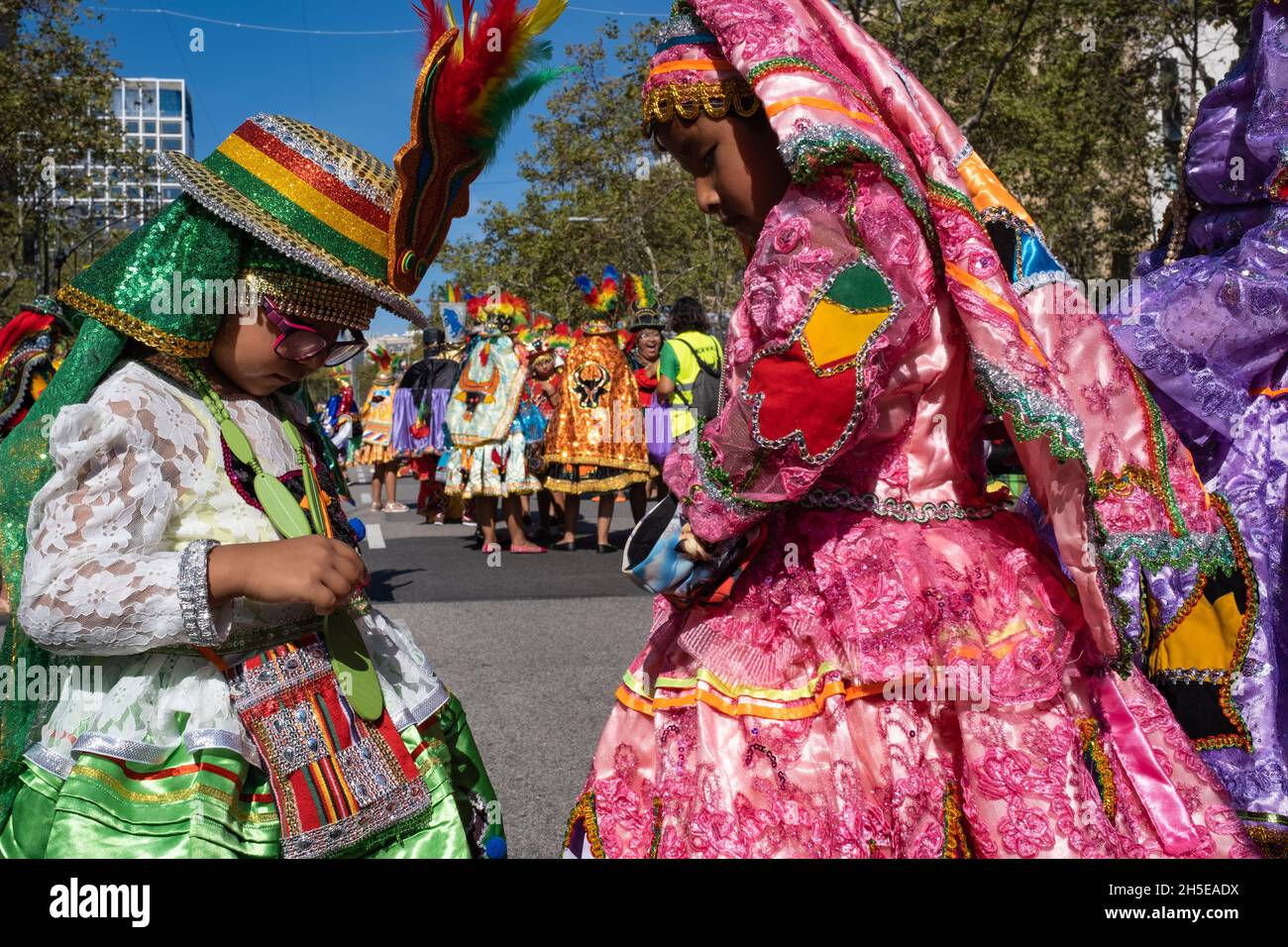 Barcelone, Espagne - Journée hispanique, 2021: Deux filles boliviennes ethniques vérifient leurs costumes traditionnels avant de défiler dans les rues de la ville. Banque D'Images