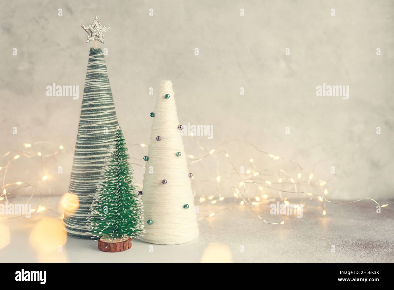 Arbres de Noël faits main.Arbres coniques et guirlande enveloppés de fils.Décorations artisanales pour décorer votre maison pendant les vacances - image Banque D'Images