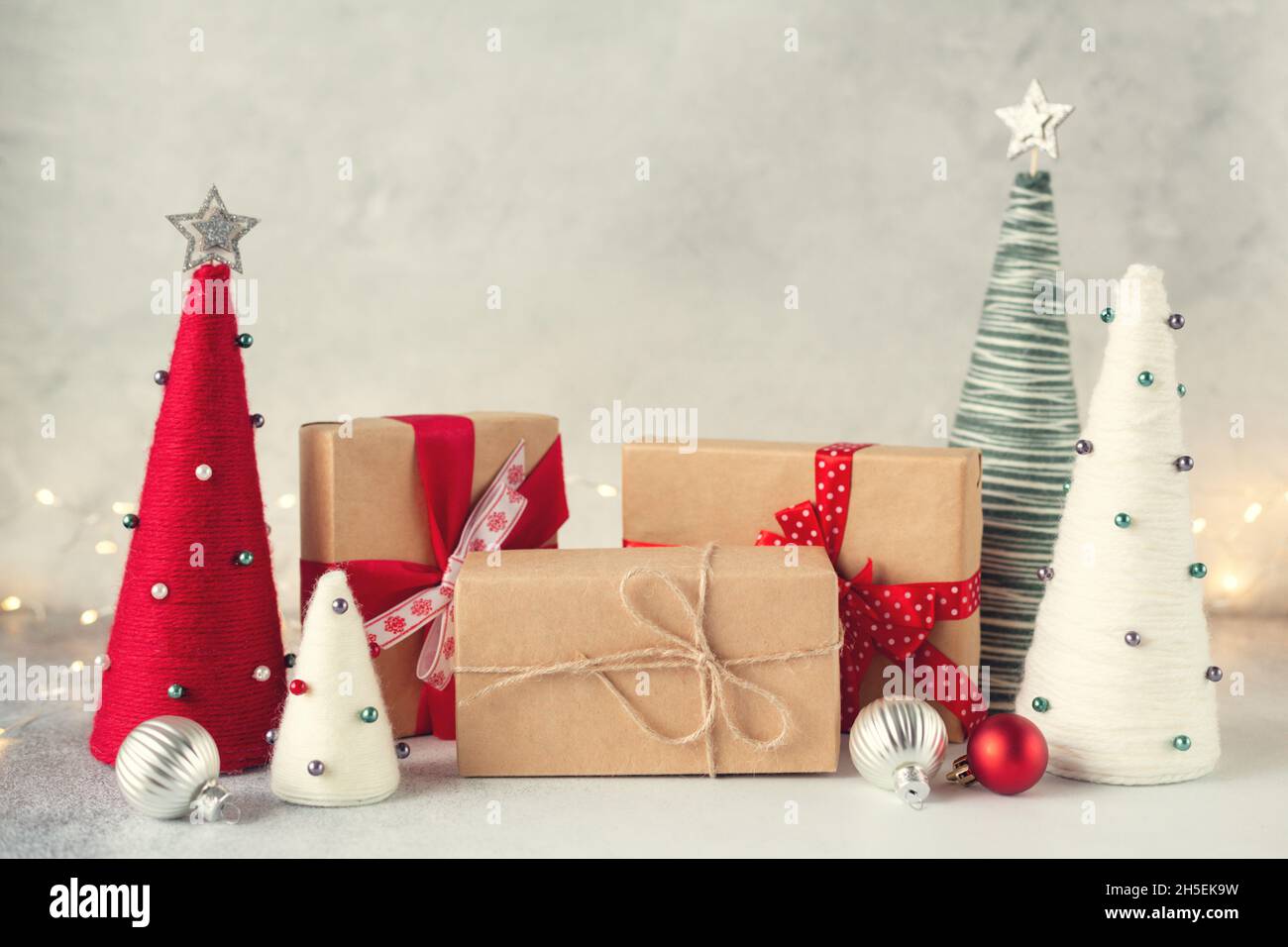 Composition de Noël avec boîtes cadeaux et arbres de Noël en forme de cône emballés de fils.Guirlande sur fond - image Banque D'Images