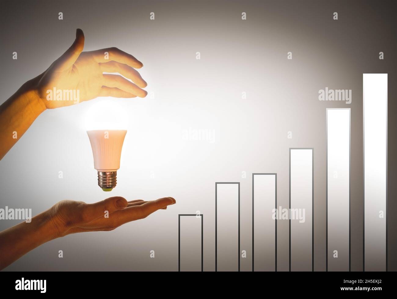 Ampoule à main. Le concept de l'éco-énergie, l'innovation.Graphique de croissance avec les mains éclairées par une ampoule LED. Banque D'Images