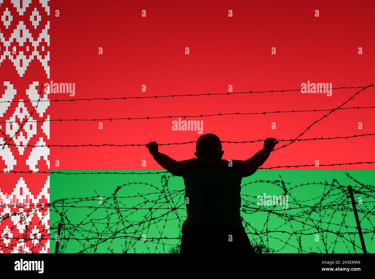 Homme regardant à travers la barrière barbelée avec le drapeau de la Biélorussie se chevauchait.Frontière Biélorussie/UE/Pologne, immigrants illégaux, asile, Europe... concept Banque D'Images