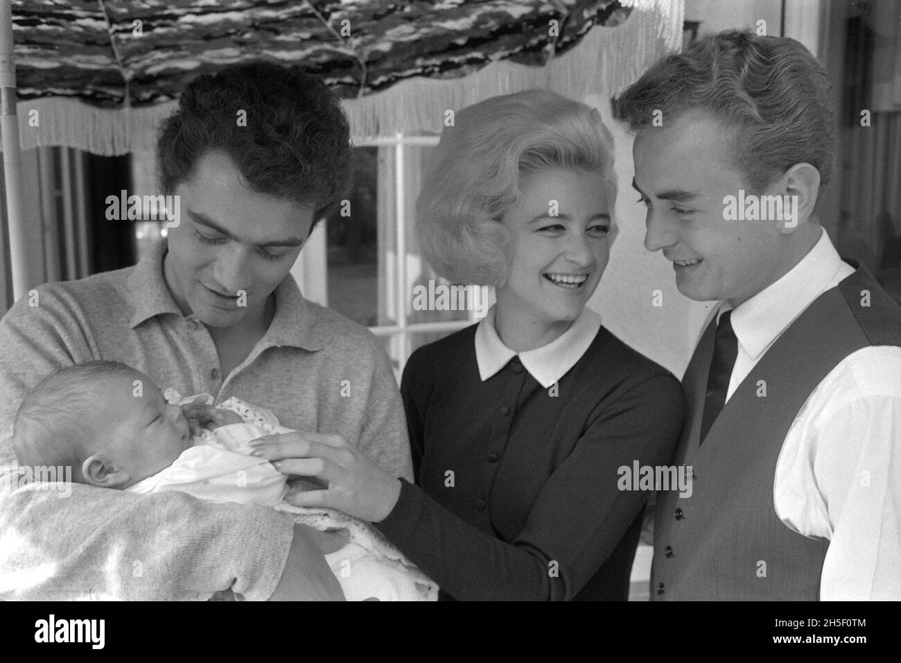 Hans-Juergen BAEUMLER, Hans-JÃ rgen BÃ umler, à gauche, patineur de figure, visite le couple Marika KILIUS, patineuse de figure, et Werner ZAHN, entrepreneur, et tient le bébé ZAHN, dans ses bras, photo non datée, ca.1965, Â Banque D'Images