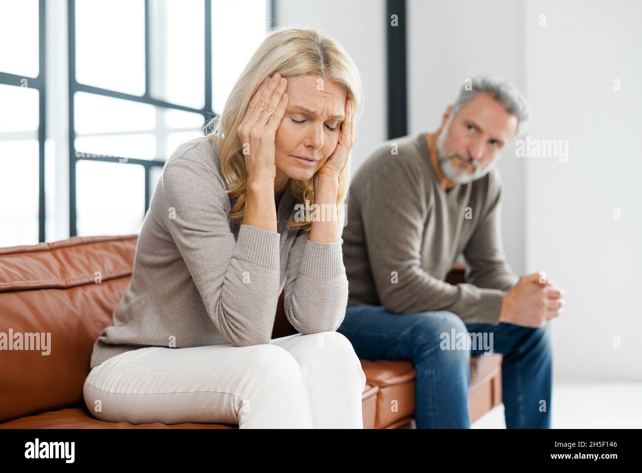 Couple senior frustré à la maison.Beau gris-cheveux mûr homme et la femme attrayante d'âge moyen ont des problèmes de relation, près du divorce, assis sur le canapé et garder silencieux dans une querelle Banque D'Images