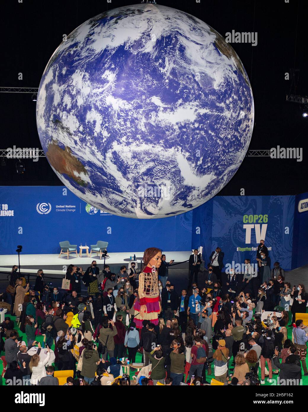 Glasgow, Écosse, Royaume-Uni.9 novembre 2021.PHOTO : la marionnette géante « Little Amal » occupe le devant de la scène dans l'arène OVO à la conférence COP26 sur les changements climatiques avec une bannière en dessous dévoilant les mots « 1.8 MILLIONS DE PERSONNES DISENT: CSAVE OUT FUTURE NOW » Credit: Colin Fisher/Alay Live News Banque D'Images