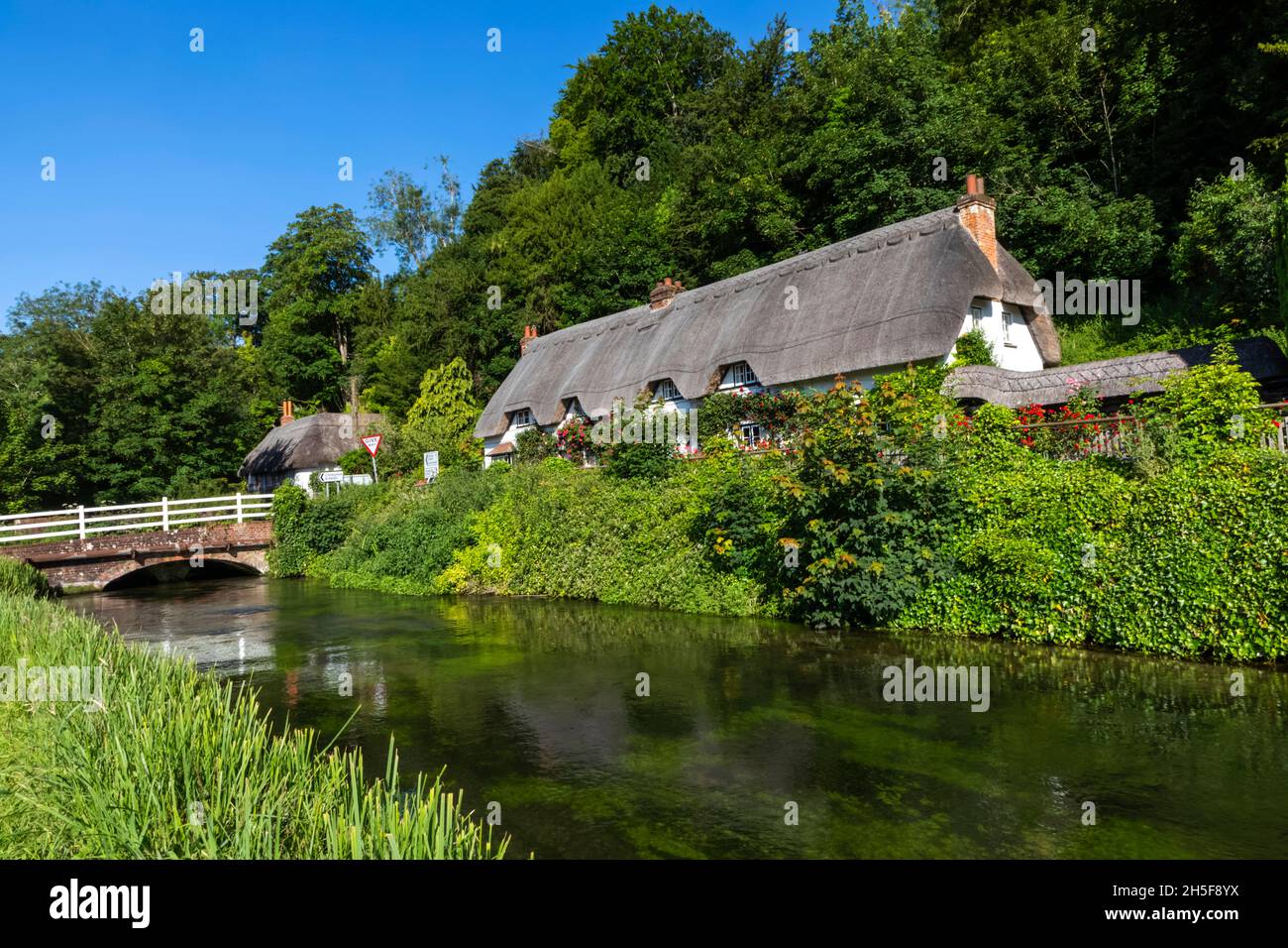 Angleterre, Hampshire, Test Valley, Wherwell, maison de campagne traditionnelle de chaume et River Test Banque D'Images