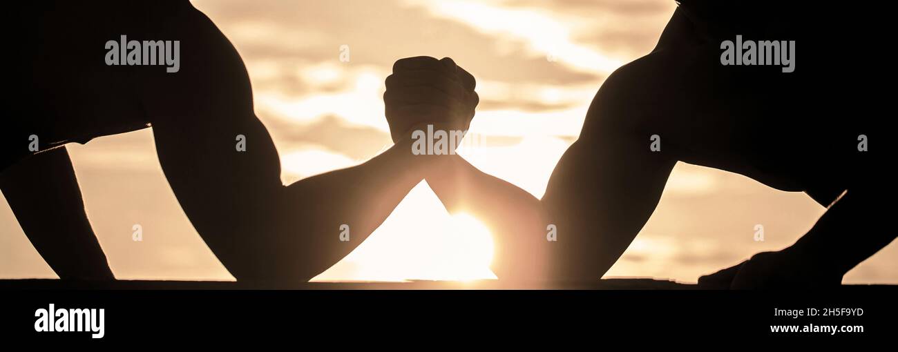 Rivalité, gros plan de lutte de bras mâle.Hommes mesurant les forces, les bras.Deux hommes luttant.Rivalité, vs, défi, lutte de main.Lever du soleil Banque D'Images