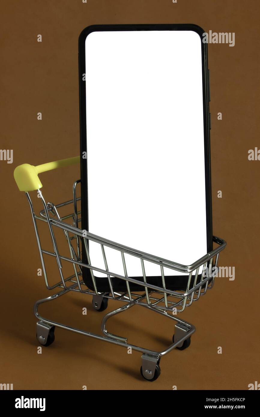 Smartphone avec écran blanc isolé dans un panier métallique dans le magasin.Concept d'entreprise en ligne Banque D'Images