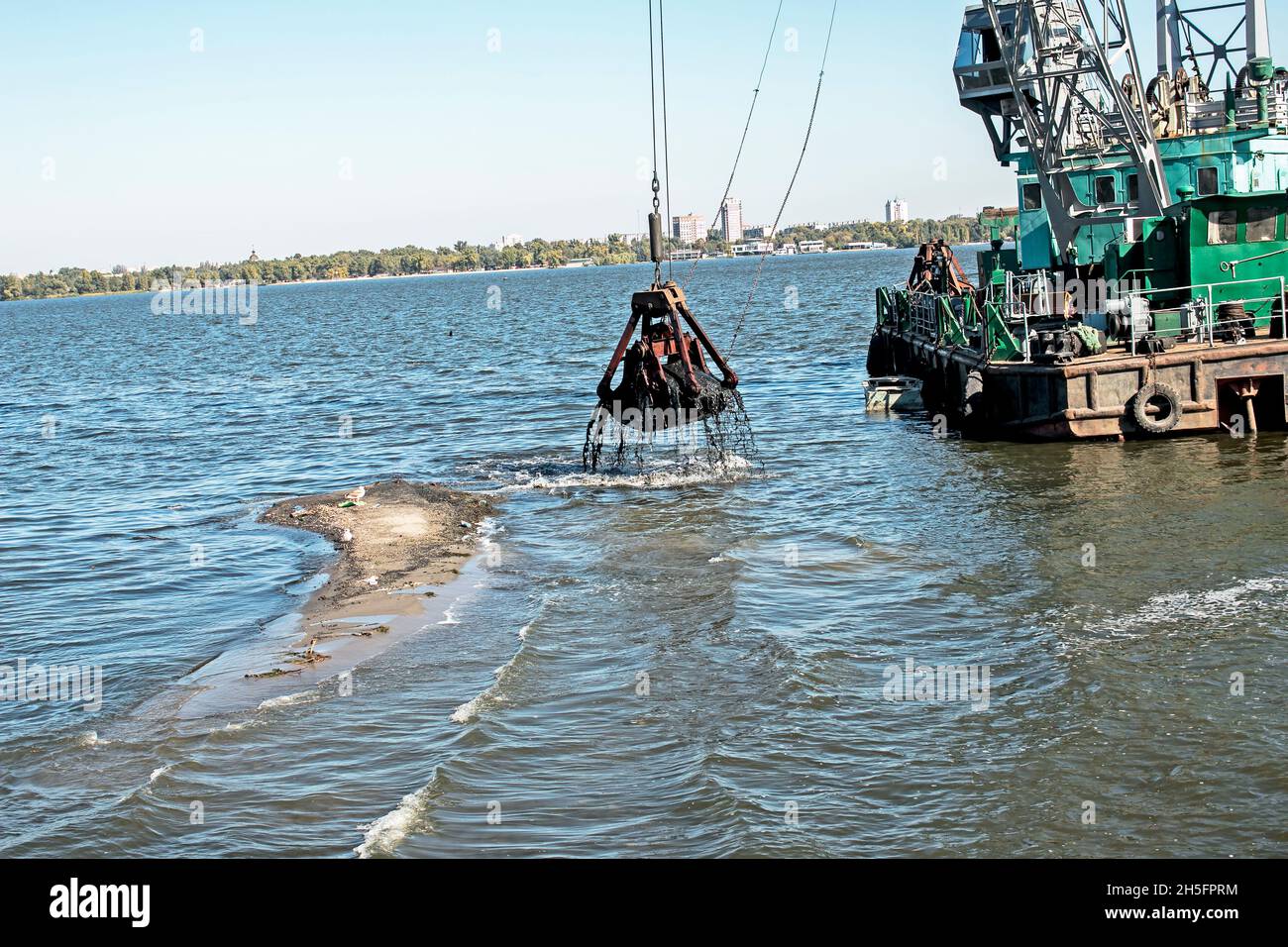 Nettoyage de l'île nouvellement formée des déchets industriels sur la rivière Dniepr par un dragueur.Problèmes environnementaux des rivières modernes.Concept d'écologie. Banque D'Images