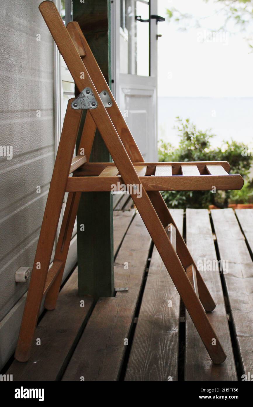 Leerer Holzstuhl auf einer Veranda vor einem Mobile Home, Vir, Kroatien. Banque D'Images
