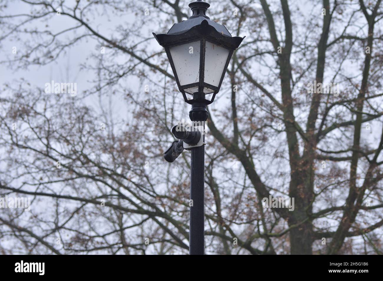Une caméra de surveillance de la ville montée sur un phare historique lors d'un sombre jour d'automne. Banque D'Images