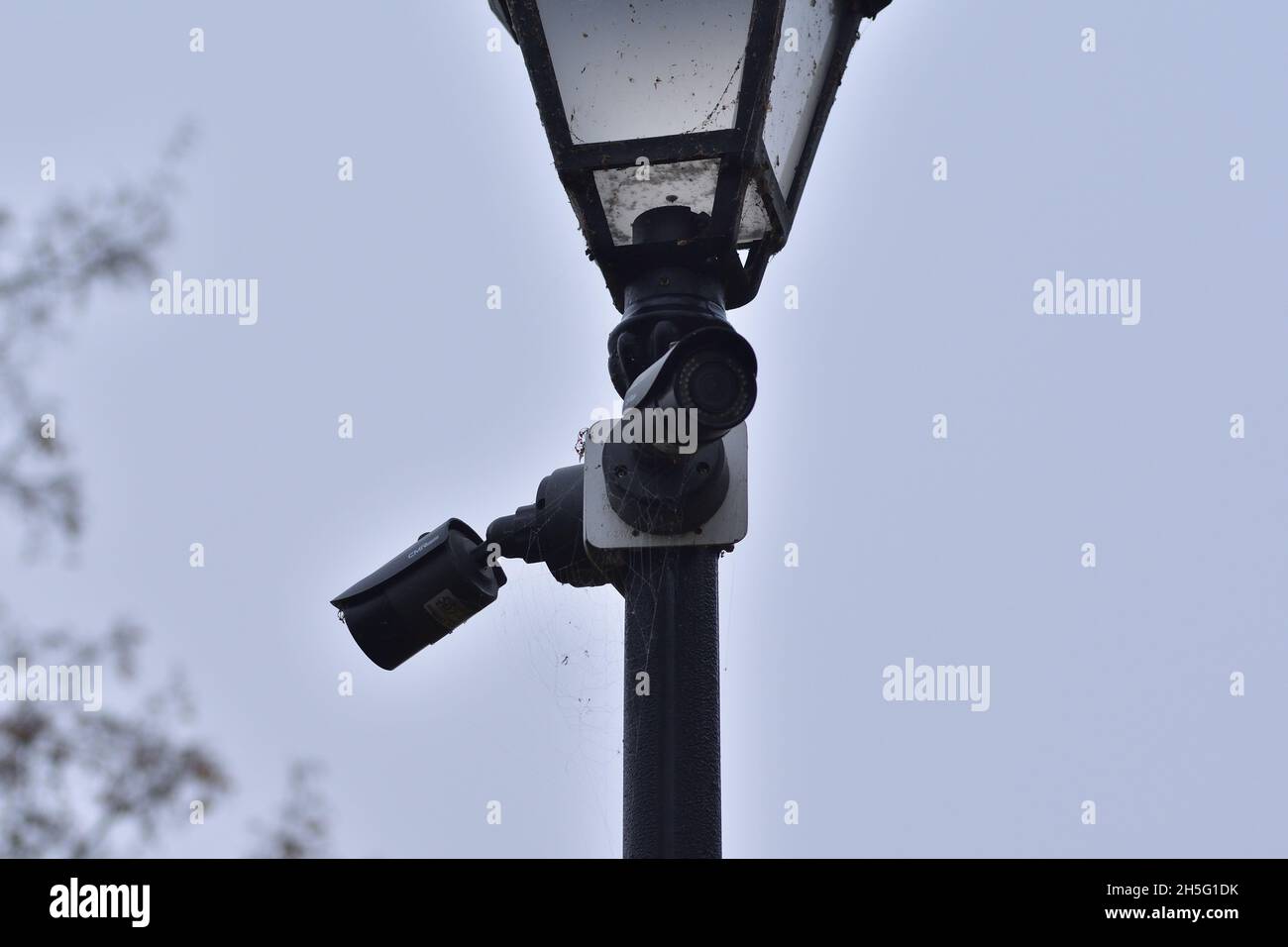 Une caméra de surveillance de la ville montée sur un phare historique lors d'un sombre jour d'automne. Banque D'Images