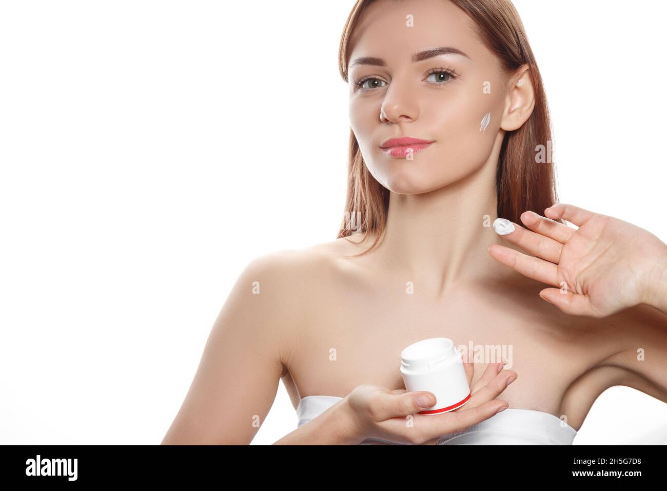 Concept de cosmétologie : portrait d'une fille tenant de la crème dans ses mains Banque D'Images