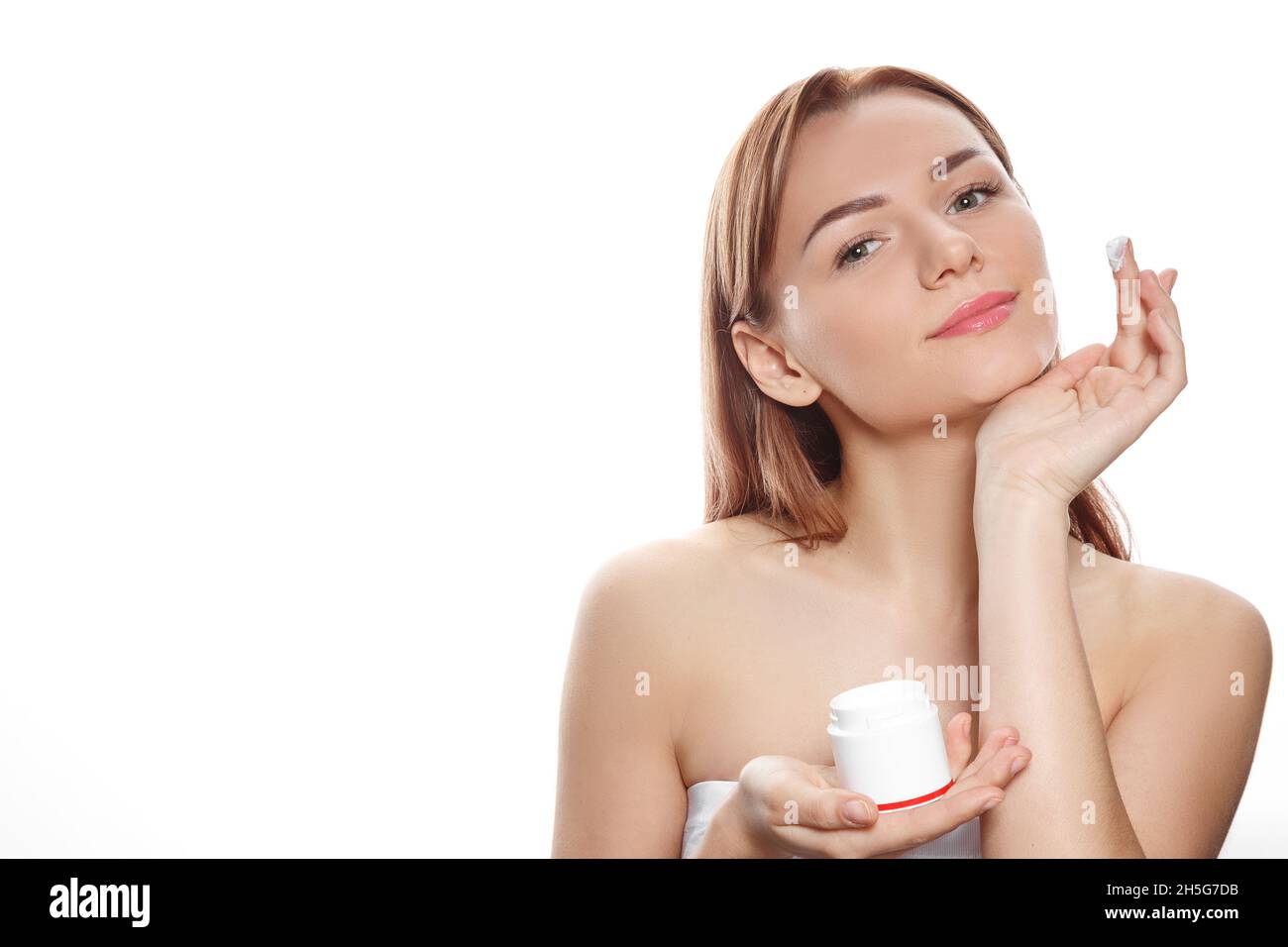 Concept de cosmétologie : portrait d'une fille tenant de la crème dans ses mains Banque D'Images