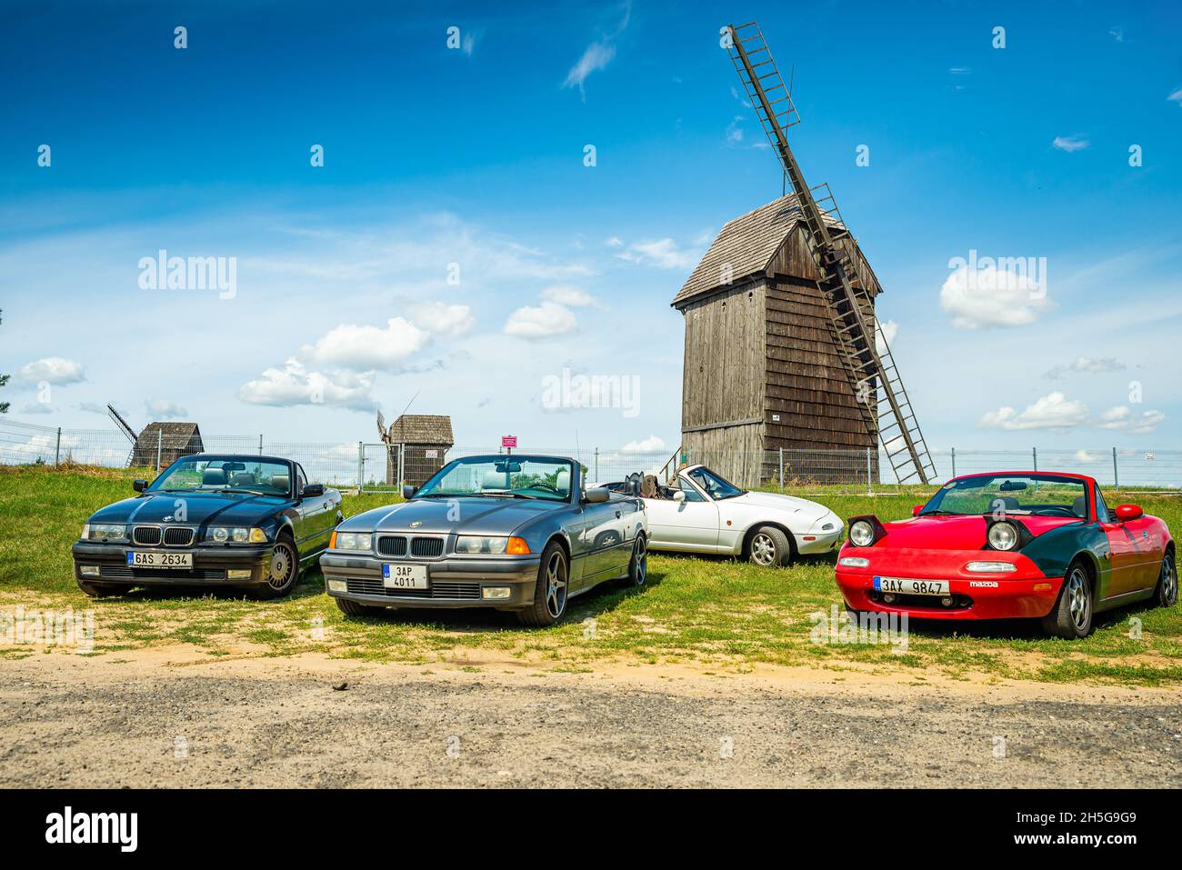 Moraczewo, Pologne - 09 août 2021.L'ancienne BMW e36 décapotable et Mazda MX5 Miata garées devant des moulins à vent en bois sur la route Banque D'Images