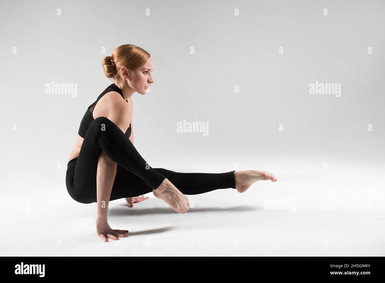 Un entraîneur professionnel de yoga et de pilates montre des exercices de yoga, pilates, stretching et d'autres types de forme physique sur un tapis avec l'équipement, avec des fitnes Banque D'Images
