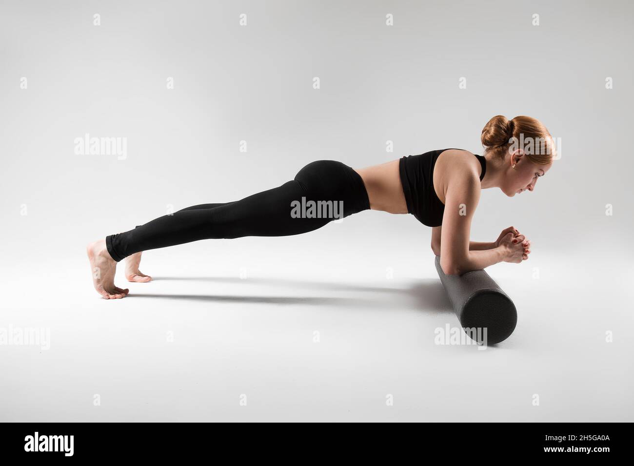 Un entraîneur professionnel de yoga et de pilates montre des exercices de yoga, pilates, stretching et d'autres types de forme physique sur un tapis avec l'équipement, avec des fitnes Banque D'Images