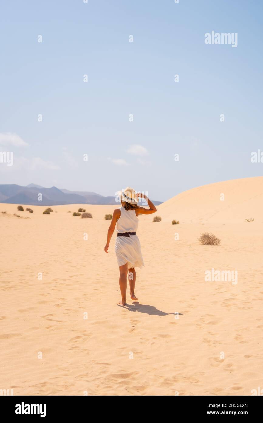 Plan vertical de jeunes femmes marchant dans les dunes du parc naturel de Corralejo, Espagne Banque D'Images