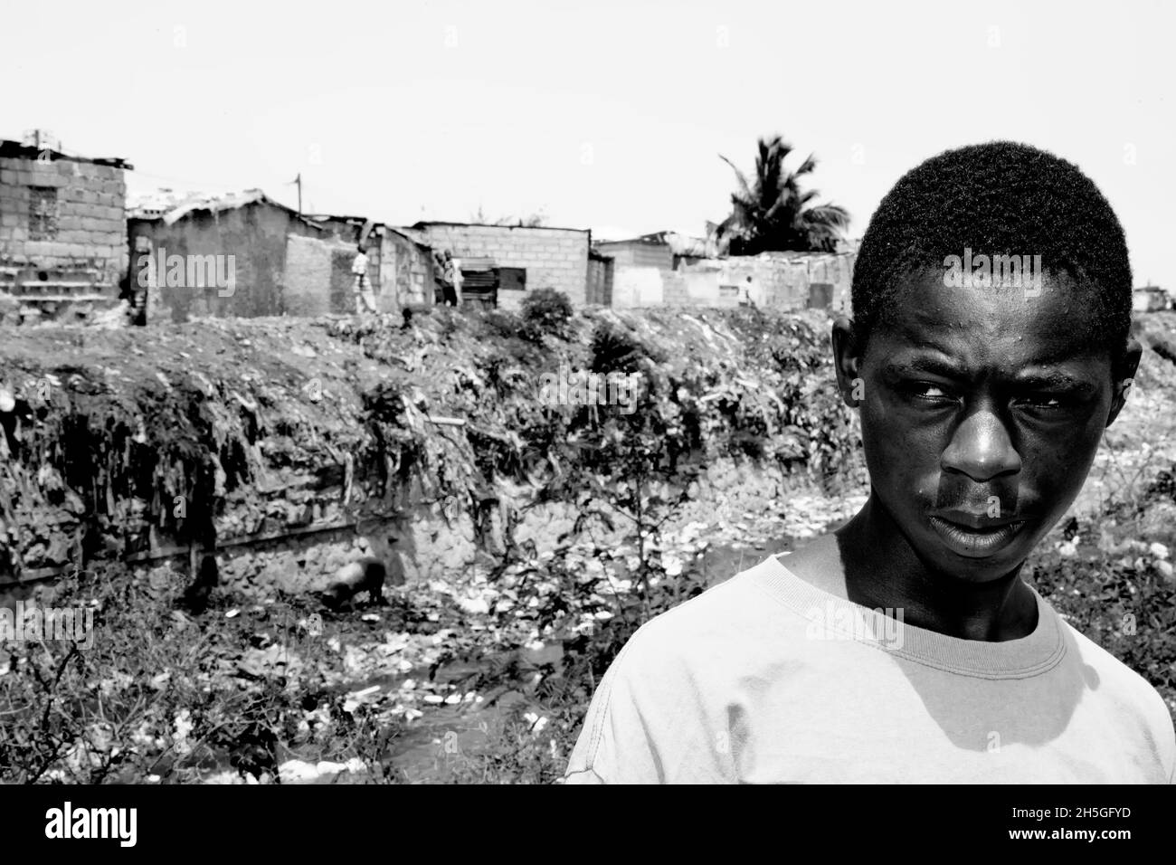 Un garçon marche entre les ghettos de Bel Air et de City Soleil. Banque D'Images