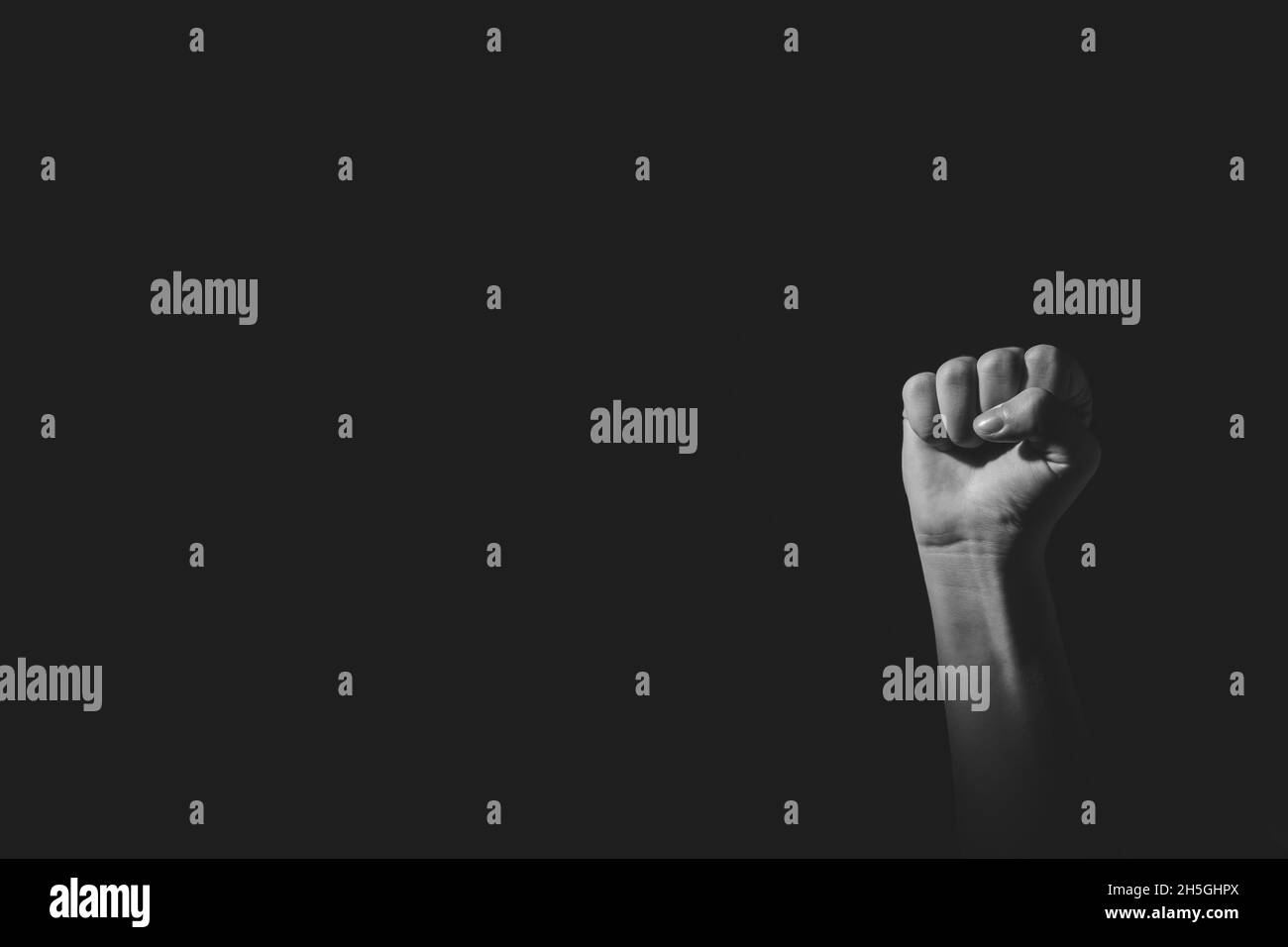 Poing poser main avec lumière et ombre, noir et blanc, isolé sur noir Banque D'Images