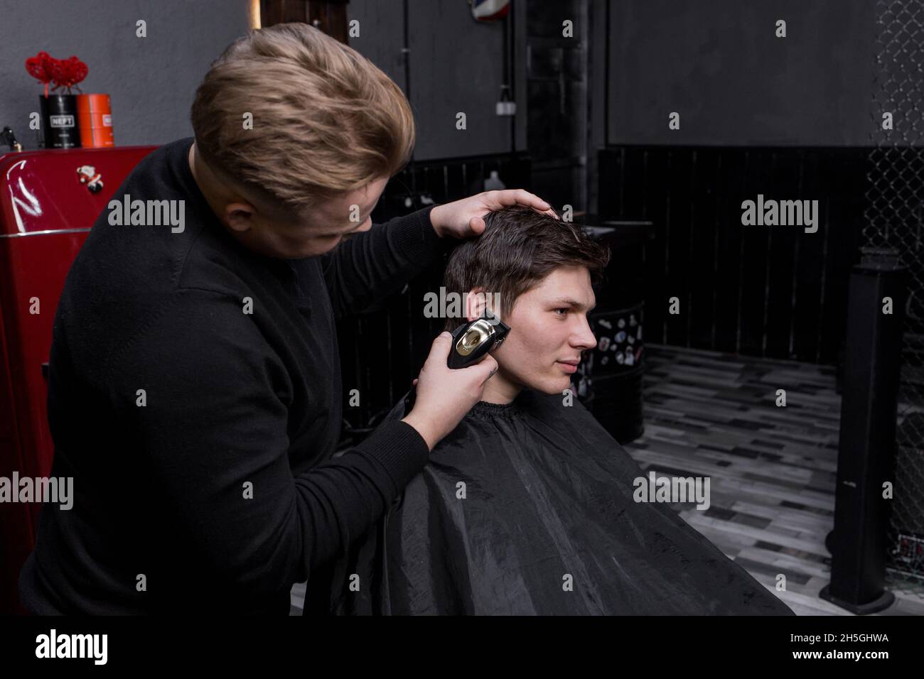 Du Son Pour Les Gars Sur La main d'un coiffeur ou d'un coiffeur coupe les cheveux longs sombres