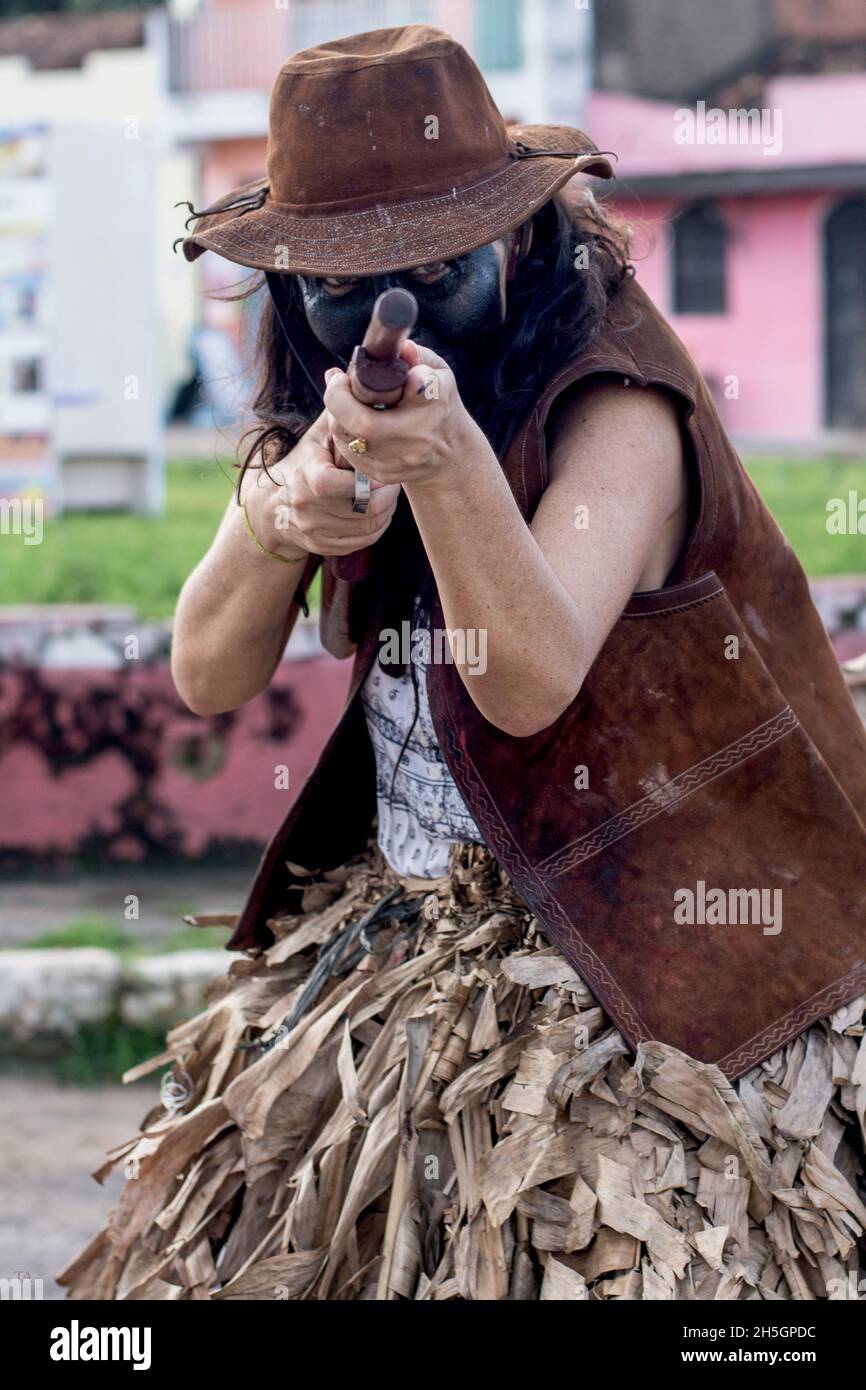 Femme caucasienne avec visage de couleur noire.Elle porte un chapeau rose  et pointe un pistolet sur la caméra.Acupe, Bahia, Brésil Photo Stock - Alamy