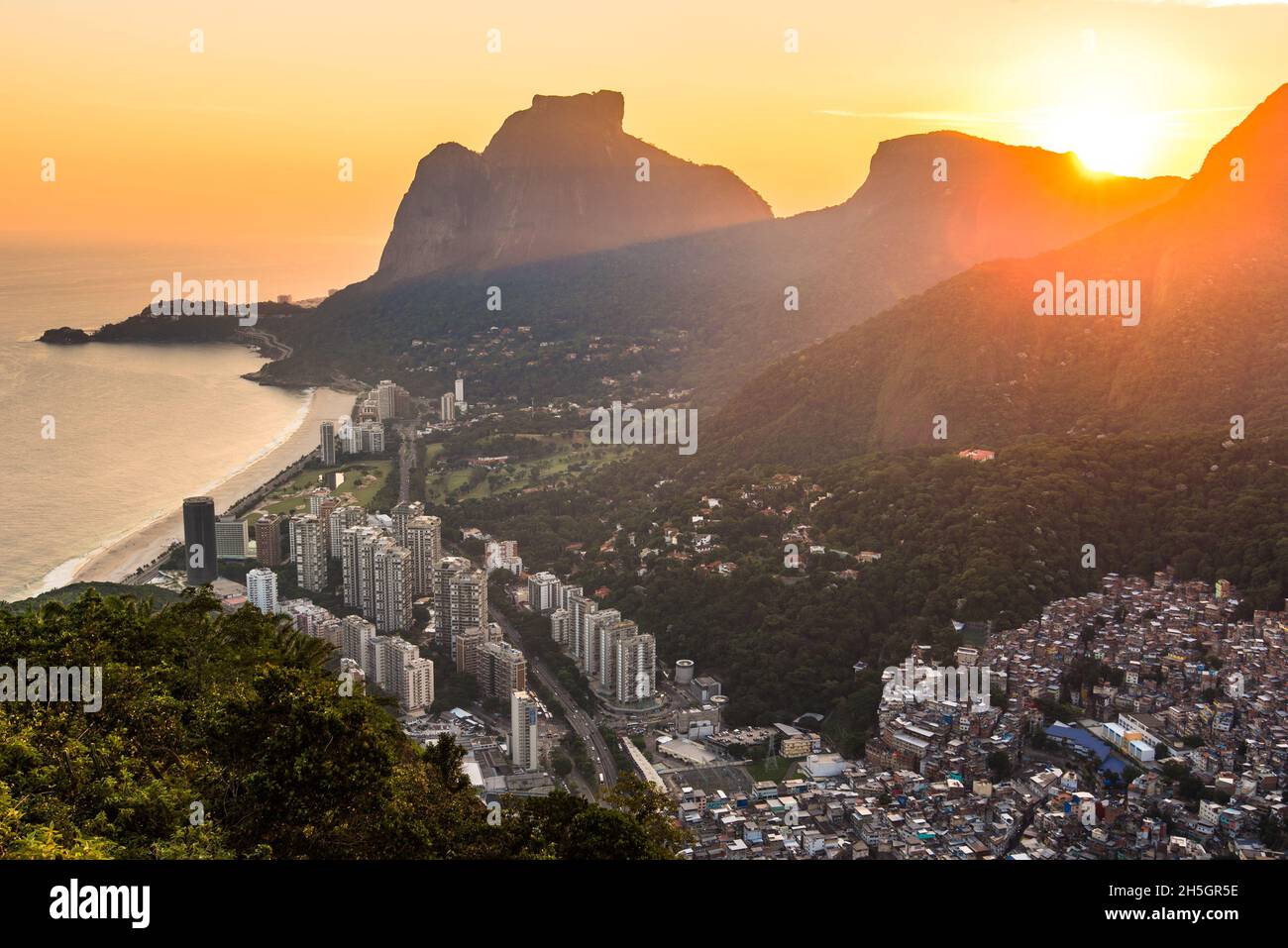 Vue sur Sao Conrado pendant un magnifique coucher de soleil coloré derrière les montagnes de Rio de Janeiro, Brésil Banque D'Images